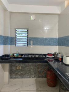 a kitchen with a stove and a counter top at Maria's Homestay in Siliguri
