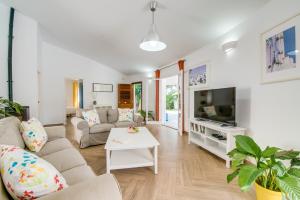 ein Wohnzimmer mit einem Sofa und einem TV in der Unterkunft Casa Encinar in Crestatx