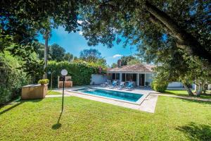 a backyard with a swimming pool and a house at Ideal Property Mallorca - Casa Pequeña in Crestatx