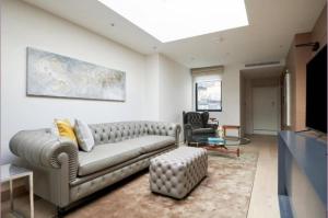sala de estar con sofá y TV en Maddox Street - 3 bed en Londres