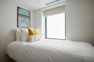 1 dormitorio con 1 cama blanca grande y ventana en Maddox Street - 3 bed en Londres