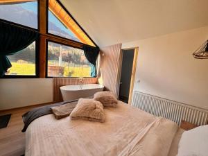 a bedroom with a bed and a tub and a window at View Piatra Craiului in Zărneşti