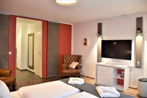 a hotel room with a bed and a flat screen tv at Studio-Apartment Augarten in Vienna