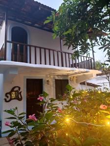 una casa blanca con una escalera y algunas flores en The Funky Monkey Hostel, en Anjuna