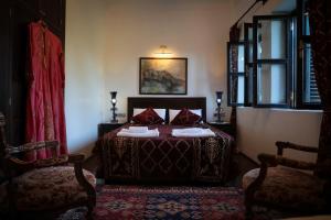 a bedroom with a bed and two chairs at Hadrianus Hotel in Antalya