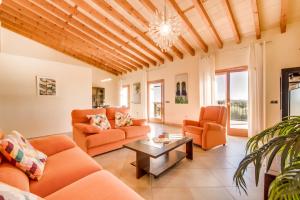 una sala de estar con muebles de color naranja y techo de madera. en Es Puchet, en Búger