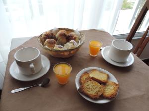 Hotel My Way في مار ديل بلاتا: طاولة مع وعاء من الخبز وأكواب من القهوة