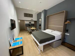 Travel Habitat Benimaclet Vista Hermosa Suites في فالنسيا: غرفة نوم بسرير كبير وغرفة طعام