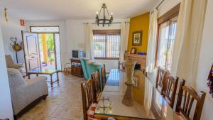 comedor y sala de estar con mesa y sillas en El Romo Colmenar by Ruralidays, en Colmenar