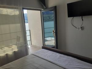 a bedroom with a bed and a window with a view at Cazanele Dunarii "La Cumatru" in Dubova