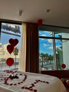 a bedroom with red hearts on a bed with a window at Marina Premium Hotel in Vlorë