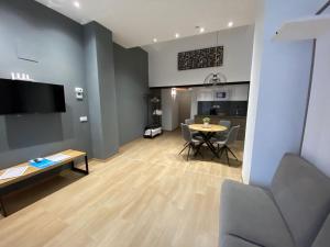 sala de estar con mesa y cocina en Travel Habitat Benimaclet Vista Hermosa Suites, en Valencia