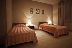 duas camas num quarto de hotel com duas lâmpadas em Apartments Nevsky 150 em São Petersburgo