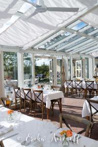 a dining room with white tables and chairs at Fredriksborg Hotell & Restaurang in Värmdö