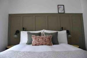 a bed with a large headboard with a pillow on it at Teach Róise Eoin in Loughanure
