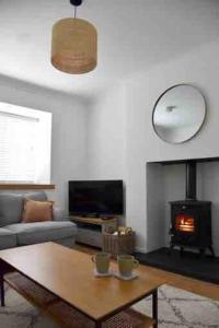 a living room with a coffee table and a fireplace at Teach Róise Eoin in Loughanure