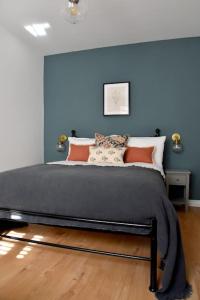 Bett in einem Zimmer mit blauer Wand in der Unterkunft Teach Róise Eoin in Loughanure