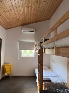 a bedroom with two bunk beds and a window at Horta do Vale - Nature House in Odeceixe