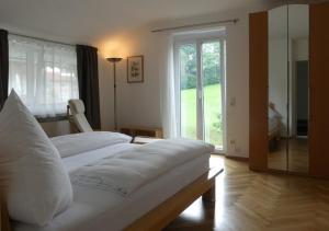 a bedroom with two beds and a large window at Kaufhold Ferienwohnung in Immenstadt im Allgäu