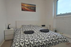 a bedroom with a black and white bed with two pillows at Urokliwy Apartament Bałtyk 2 nieopodal Gdyni NEW in Pogórze