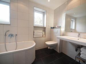 a bathroom with a tub and a toilet and a sink at Kaufhold Ferienwohnung in Immenstadt im Allgäu +13 photos