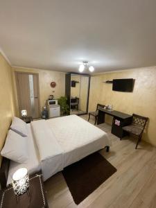 a bedroom with a large bed and a desk at Guest House SunRise in Kamianets-Podilskyi