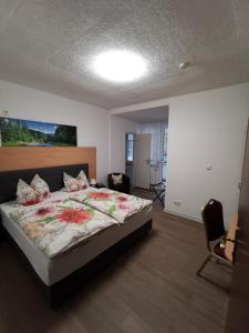 ein Schlafzimmer mit einem großen Bett mit Blumen darauf in der Unterkunft Hotel Pension Wiesenau in Bad Salzhausen