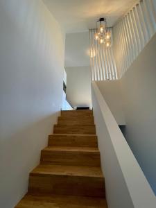 a staircase in a house with white walls and wooden floors at Vakantieappartement Logies Terhagen in Zoutleeuw