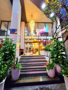 a store front with stairs and potted plants in front at LEHA Saigon Hotel Airport in Ho Chi Minh City