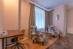 波亞納布拉索夫的住宿－Casa Nostalgia，客厅配有两把椅子和一张桌子
