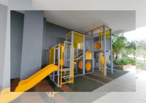 une aire de jeux avec toboggan jaune dans une pièce dans l'établissement 2R2B Cozy Homestay,1-7 Pax - GA2, à Shah Alam