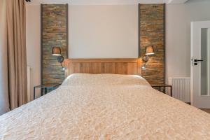 a bedroom with a large bed with two lamps on it at Casa Nostalgia in Poiana Brasov