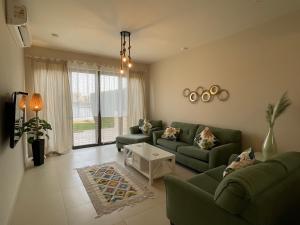 a living room with two green couches and a table at Luxury 3BR Townhouse, Tawila, El Gouna, Lagoon & Pool access in Hurghada