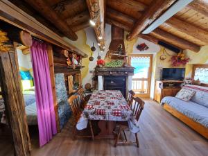 una sala da pranzo con tavolo e un letto in una stanza di Chalet L'Ange Des Neiges - Relax & SPA a Valtournenche