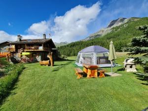 a tent and a table in front of a house at Chalet L'Ange Des Neiges - Relax & SPA in Valtournenche