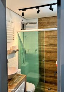a bathroom with a shower and a toilet and a sink at Condominio Amarilis Flat in Riviera de São Lourenço