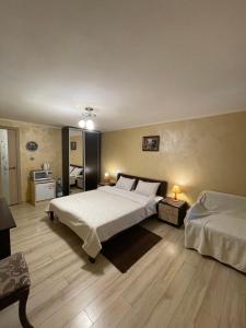 - une grande chambre avec 2 lits et un réfrigérateur dans l'établissement Guest House SunRise, à Kamianets-Podilsky