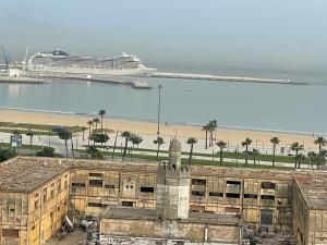 statek wycieczkowy w oceanie z budynkiem i plażą w obiekcie STUDIO BORJ RAYHANE w mieście Tanger