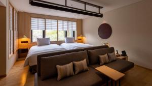 a hotel room with two beds and a couch at Fufu Kyoto in Kyoto