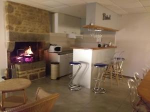 a kitchen with a fireplace and a table and chairs at Le Cottage de L Abbaye in Lonlay-lʼAbbaye
