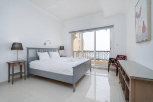 a bedroom with a bed and a large window at Stunning 2BD Sea View Apartment Private Beach Access in Ras al Khaimah