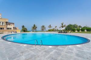 a large blue swimming pool in a resort at Stunning 2BD Sea View Apartment Private Beach Access in Ras al Khaimah