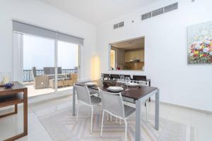 a kitchen and dining room with a table and chairs at Stunning 2BD Sea View Apartment Private Beach Access in Ras al Khaimah
