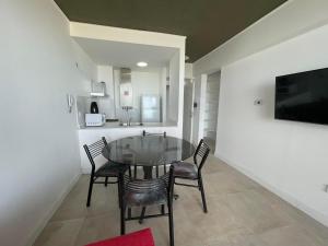 a dining room with a glass table and chairs at Departamento frente al mar en Monte Hermoso in Monte Hermoso