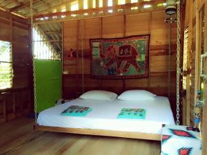 チャン島にあるHappy Hippy House2の壁に絵が描かれた部屋のスイングベッド1台