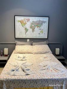 a bedroom with a bed with a map on the wall at Condominio Amarilis Flat in Riviera de São Lourenço