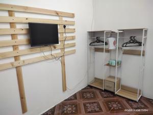 a living room with a tv on a wall at Bulat Cottage in Pantai Cenang