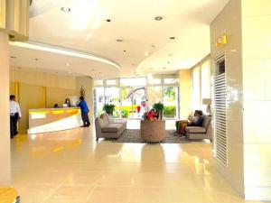 a lobby with people sitting in chairs in a building at Stylish 1BR with Wifi and Queen size bed in Grace Res in Manila