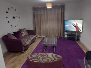 a living room with a couch and a tv at Superb 2 bedroom flat, sleeps 6 in Croydon