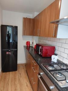 eine Küche mit einem schwarzen Kühlschrank und einer schwarzen Arbeitsplatte in der Unterkunft Superb 2 bedroom flat, sleeps 6 in Croydon